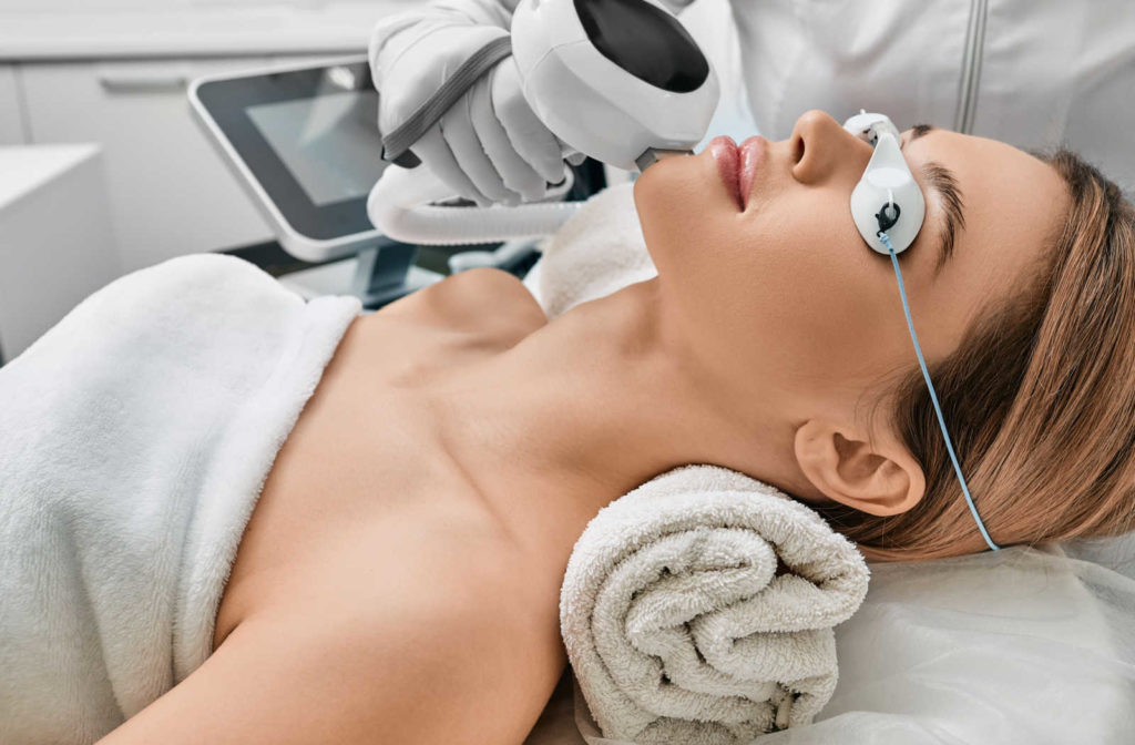 A woman receiving a laser treatment for rosacea from her aesthetician