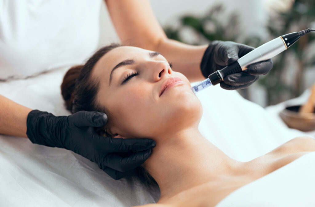 A woman having a microneedling treatment from an aesthetician for anti-aging benefits.
