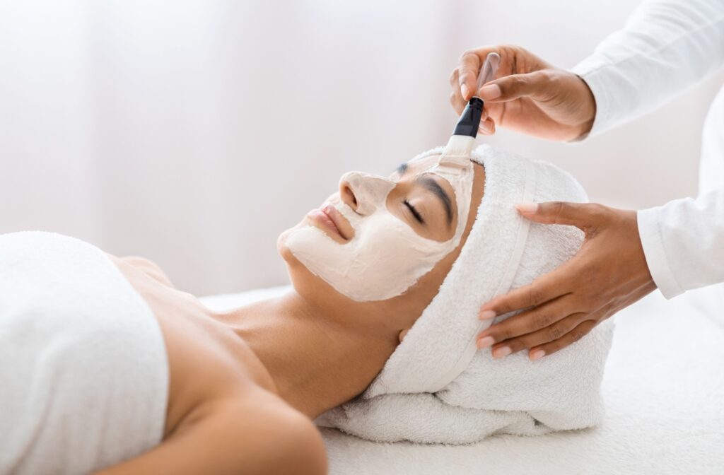a woman is getting a facial done at a medical aesthetics clinic to help reverse the effects of sun damage.