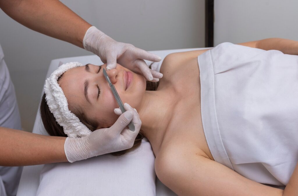 A young woman smiling during her dermaplaning treatment.